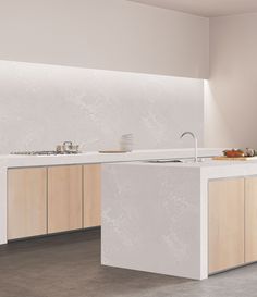 an empty kitchen with white counter tops and wooden cabinetry, along with a sink