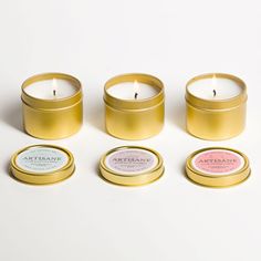 four candles sitting next to each other on a white surface