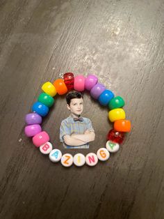 a child's photo on a beaded bracelet with the word bingin spelled in multicolored beads