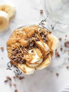 an ice cream sundae with chocolate and bananas on top, drizzled with peanut butter