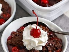 two white bowls filled with ice cream and chocolate cake desserts on top of a table