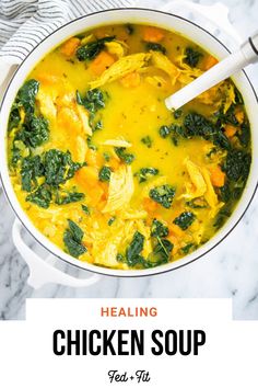 chicken soup with spinach and carrots in a white bowl