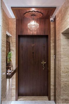 an entry way with a chandelier above the door and two lights on either side