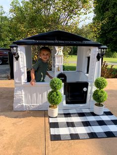 a little boy is sitting in a fake house