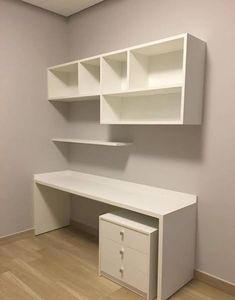 an empty room with white shelves and drawers