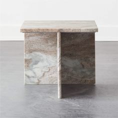 a marble box sitting on top of a hard wood floor next to a white wall