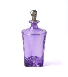a purple glass bottle with a skull head on the top is shown in front of a white background