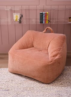 a pink bean bag chair sitting on top of a rug