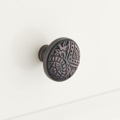 a close up of a door knob on a white surface with an intricate design in the center