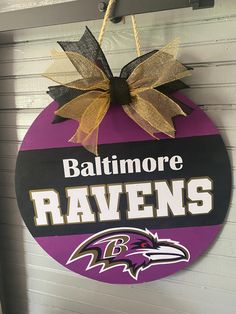 baltimore ravens sign hanging from the side of a building with a bow on it's front door