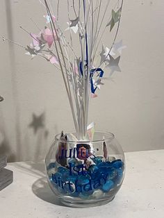 a glass vase filled with blue and white candies