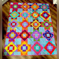 a multicolored quilt is on the floor