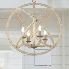 a chandelier hanging from the ceiling in a room with white walls and wood floors