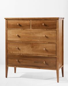 the chest of drawers is made from wood and has four drawers on one side, with three