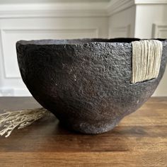 a black bowl sitting on top of a wooden table