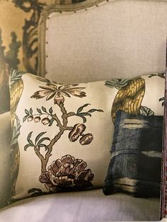 a close up of a pillow on a chair with an ornate pattern and flower design