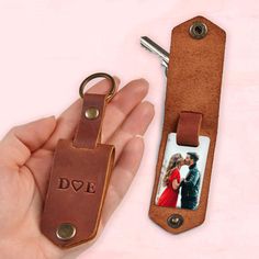 a hand holding a keychain with a photo on it