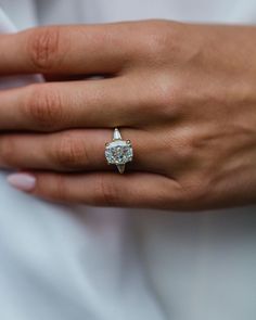 a woman's hand with a diamond ring on it