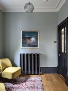 a room with a chair, radiator and rug on the floor in front of it