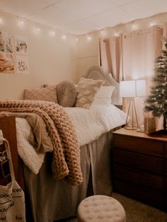 a bedroom decorated for christmas with lights on the ceiling and a tree in the corner