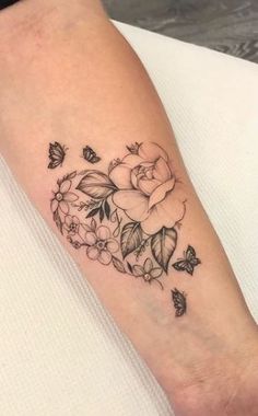 a woman's arm with flowers and butterflies on it