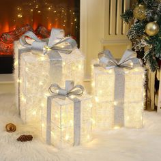 three wrapped presents sitting on top of a white fur covered floor