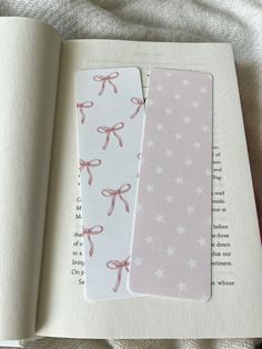 an open book with pink bows and stars on the pages, next to another bookmark