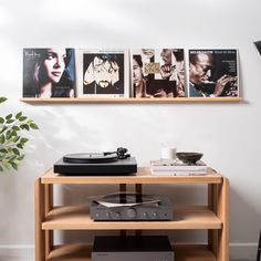 a record player sitting on top of a wooden table next to a wall mounted movie poster