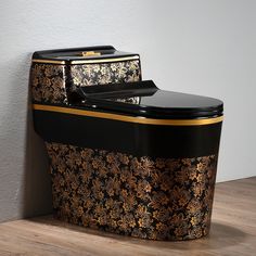 a black and gold toilet sitting on top of a wooden floor next to a wall