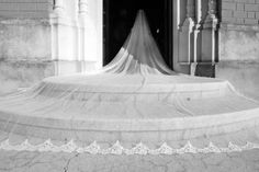 black and white photograph of a bride's veil on the steps of an old building