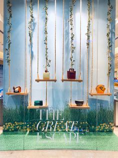 a display case with hanging plants and purses on it's sides in a retail store