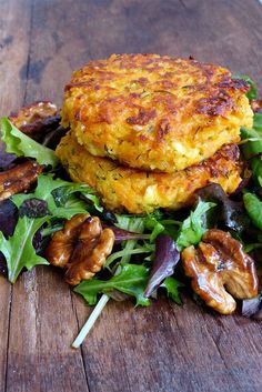 a stack of food sitting on top of a wooden table next to a pile of lettuce