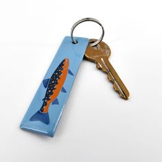 an orange and black fish is on a blue key chain