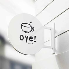 a sign that says oye coffee on the side of a building with a cup in it