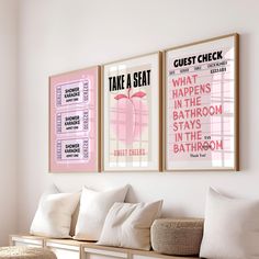 two posters are hanging on the wall above a bench in a living room with white pillows