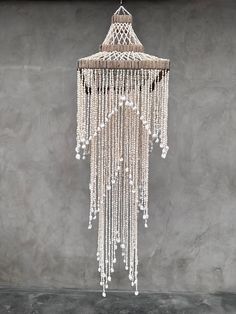 a chandelier hanging from the ceiling in a room with concrete walls and flooring