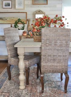 a dining room table with chairs and pictures on the wall in the backround