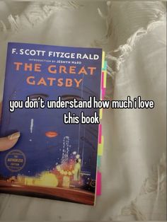 someone is reading the great gatsby book and it looks like they are in love