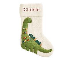 a christmas stocking with a green dinosaur on it and the word charlie written in red