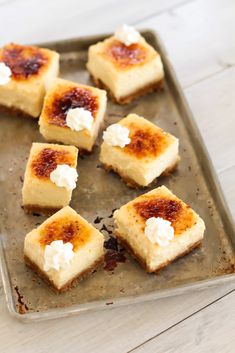 small squares of cheesecake on a baking sheet with marshmallows in the middle