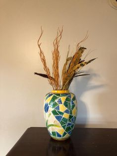 a vase with some plants in it on a table