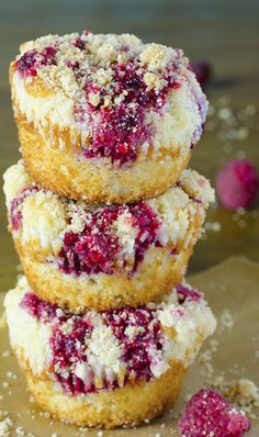 three raspberry muffins stacked on top of each other with powdered sugar