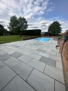 an empty pool surrounded by brick walls and grass