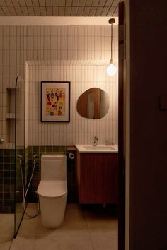 a bathroom with a toilet, sink and mirror