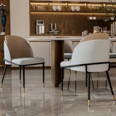 two white chairs sitting at a table in front of a counter with silverware on it