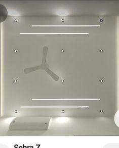 a ceiling fan in the middle of a room with lights on it and an overhead light