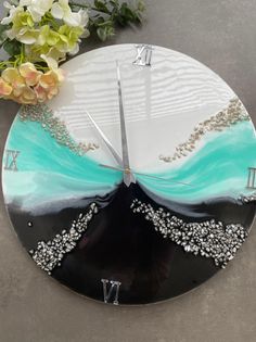 a clock made to look like an ocean wave with the number twenty on it and flowers