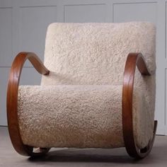 a chair that is made out of sheep's wool and has wooden legs on it