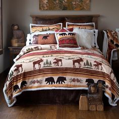 a bed with brown and white comforter, pillows and bear decorations on the cover