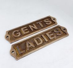 two metal signs that say gents ladies and one has the word ladies on it